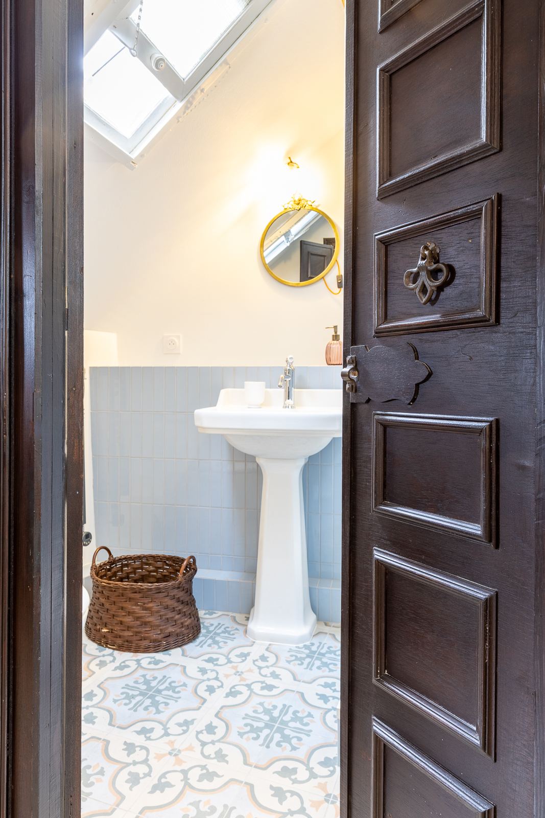 Petite pièce d'eau bleue avec carreaux de ciment et miroir doré